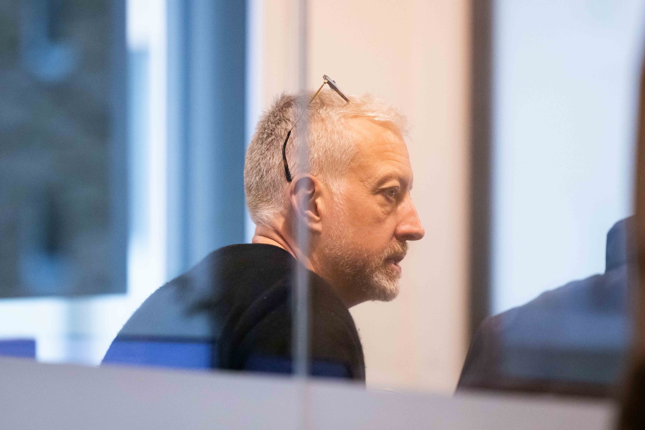 CFO Jamie Heath Captured through the glass while deeply focused in a meeting