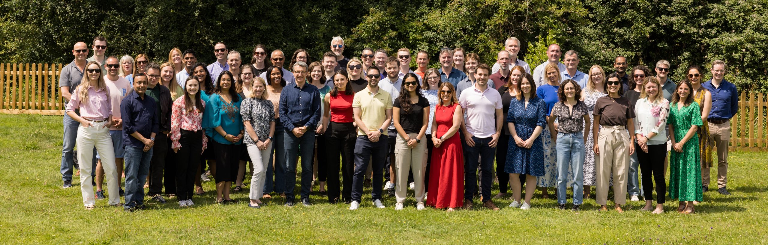 Apollo team at company meeting. Outside in the sun on grass